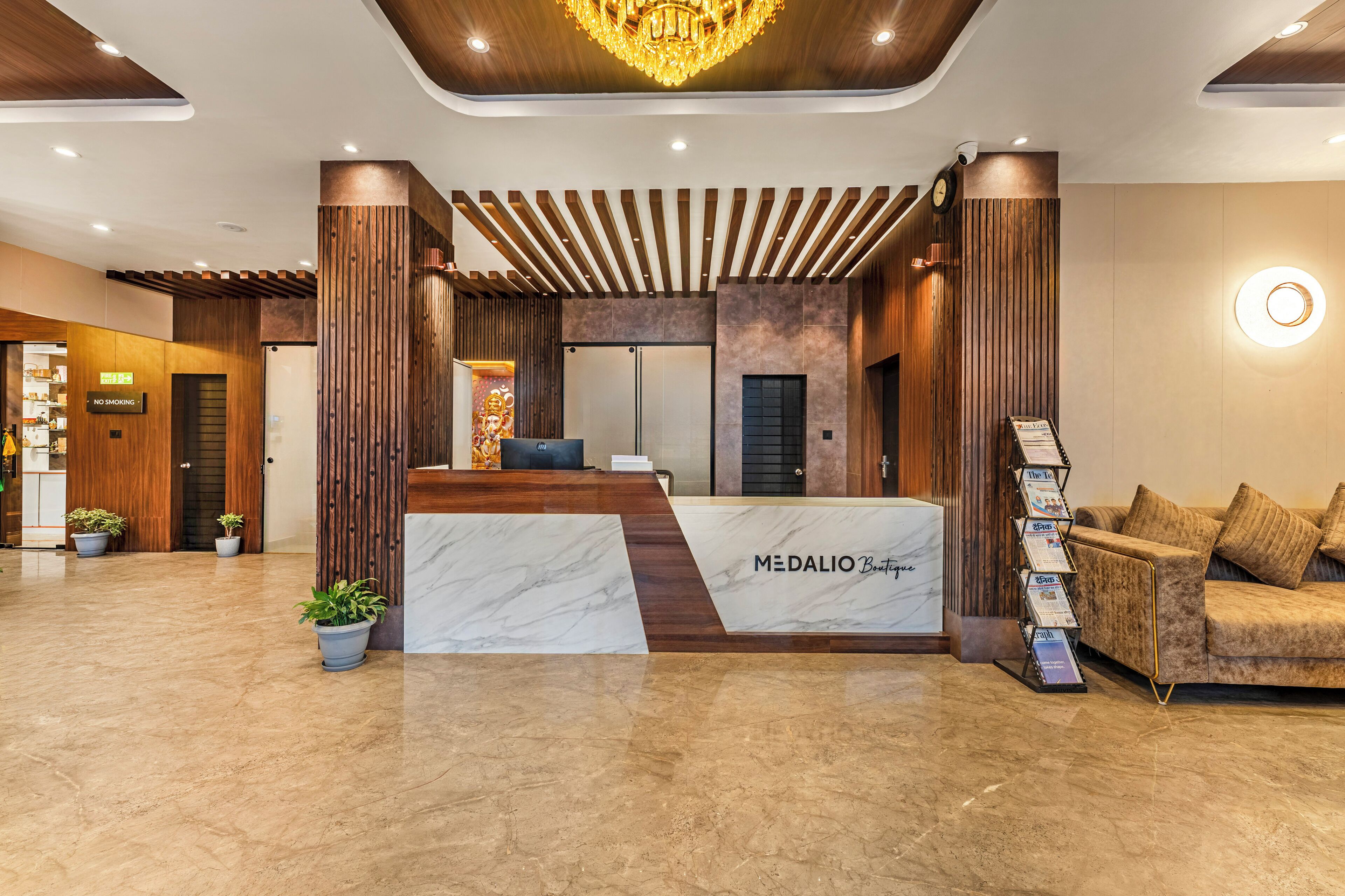 A reception area with a marble counter, wooden accents, and a chandelier.