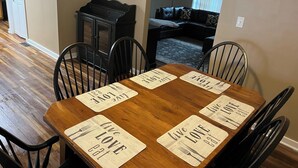 A dining table with six chairs, each with a placemat that reads "live love eat."