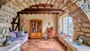 Una habitación acogedora con chimenea de piedra, un armario de madera y un sofá.