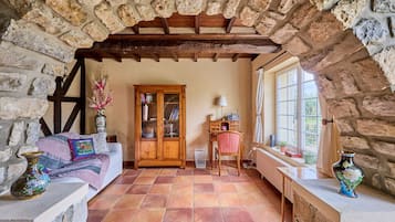 A cozy room with a stone fireplace, a wooden cabinet, and a sofa.