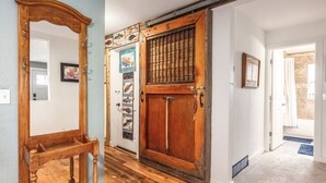 Une porte en bois portant le numéro « 5 » et ornée d’une œuvre d’art sur le thème des poissons.