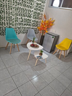 Une pièce comprenant trois chaises, une petite table et une plante décorative.