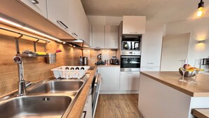 A modern kitchen with stainless steel appliances, wooden countertops, and a built-in oven. - Bright & Stylish in Nature (Brussels)