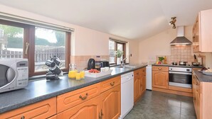 Une cuisine moderne avec des meubles en bois, un lave-vaisselle, une cuisinière et un évier.