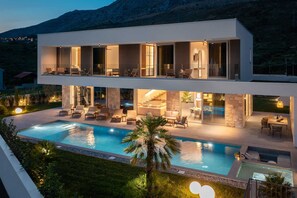 A modern two-story house with a swimming pool, outdoor seating, and a view of the mountains. - Villa ZaLú with Heated Pool (Srinjine)