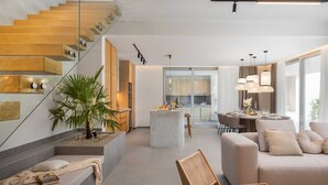 A modern living space with a staircase, a dining area, and a seating area with a sofa and a chair. - Villa ZaLú with Heated Pool (Srinjine)