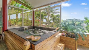 A hot tub area with a view of a lush garden and hills.