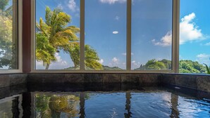 A pool with clear reflections of palm trees and a clear sky.