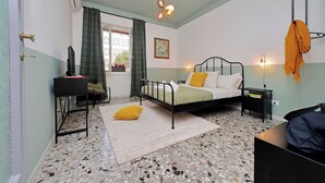 A bedroom with a bed, bedside table, and a hanging light fixture. - TM APARTMENT (Roma)