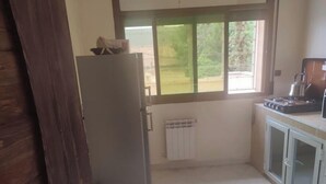 A kitchen with a refrigerator, stove, and cabinets. - Escale. 1!!

 (Midelt)