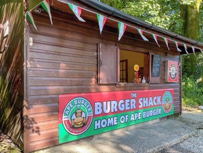 Ein hölzernes Gebäude mit einem Schild, auf dem 'The Burger Shack Home of Ape Burger' steht.
