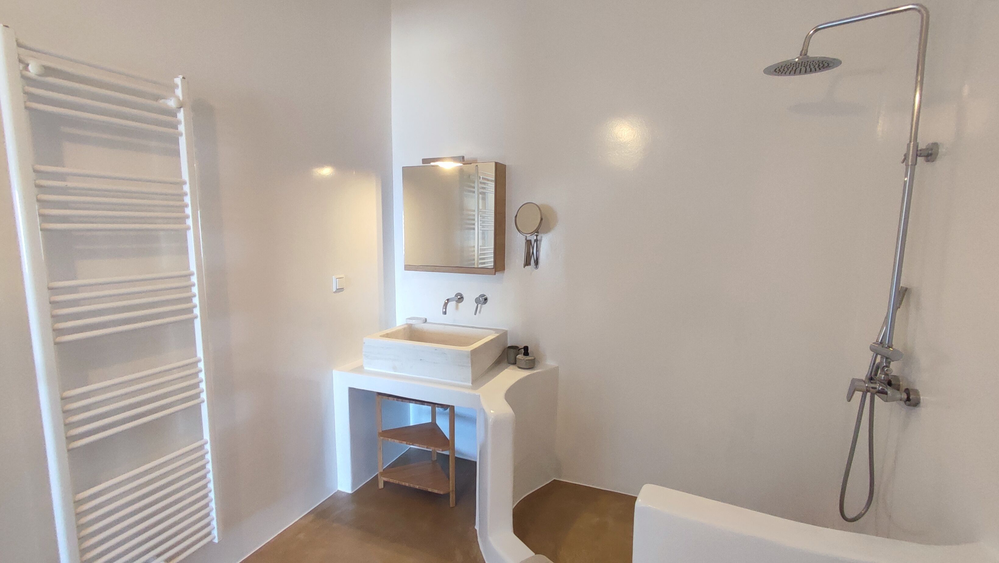 A bathroom with a white sink, mirror, and shower.