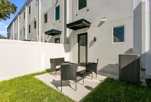Relax in style on this outdoor patio with comfortable seating and a dining table.