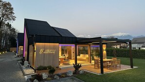 A modern building with a sign reading "Excellency" and a covered outdoor seating area.