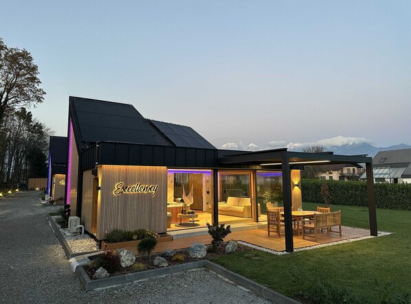 A modern building with a sign reading "Excellency" and a covered outdoor seating area.