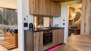 A modern kitchen with wooden cabinetry, a built-in oven, and a large island with a sink.