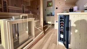 Una cocina moderna con armarios de madera, un refrigerador para vinos y una zona de sauna.