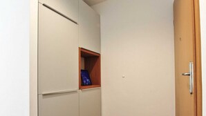 A hallway with a wardrobe, a small wooden shelf with a framed picture, and a door. - Downtown Piran Apartment with City View - Studio Apartment (Piran)