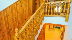 Un escalier en bois, doté d’une balustrade, menant à l’étage supérieur.