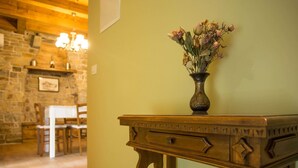 A wooden table with a vase of dried flowers against a wall with a stone fireplace. - Abitanti Rustic Apartment with Balcony - Two Bedroom Apartment with Balcony (Gračišče)