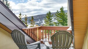 A balcony with two Adirondack chairs, a wooden railing, and a view of a snowy mountain range. - Walk to Mount Snow Resort: Unit w/ Pool & Hot Tubs (Dover)