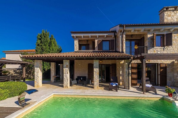 Relax in a spacious outdoor area with a large swimming pool and covered patio.