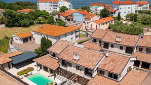 A residential area with terraced houses, a swimming pool, and a view of the sea. - Villa Forte with Heated Private Pool close to the Beach (Porat (Krk))