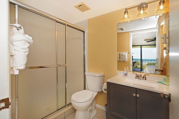 Un baño con inodoro, lavabo y ducha.