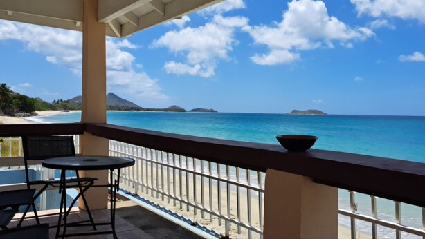 A balcony with a view of the ocean and distant islands. - PalmVille - Charming 2-bedroom house with AC, WiFi (Carriacou)