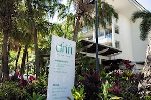 A sign listing amenities including restaurants, a juice bar, and a real estate agency.