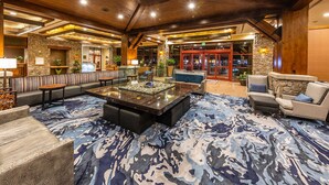 Eine großzügige Lobby mit einer gemütlichen Sitzecke, einem zentral platzierten Couchtisch und einer Wand aus Stein.