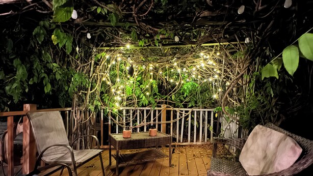 A wooden deck with wicker furniture and a white railing.