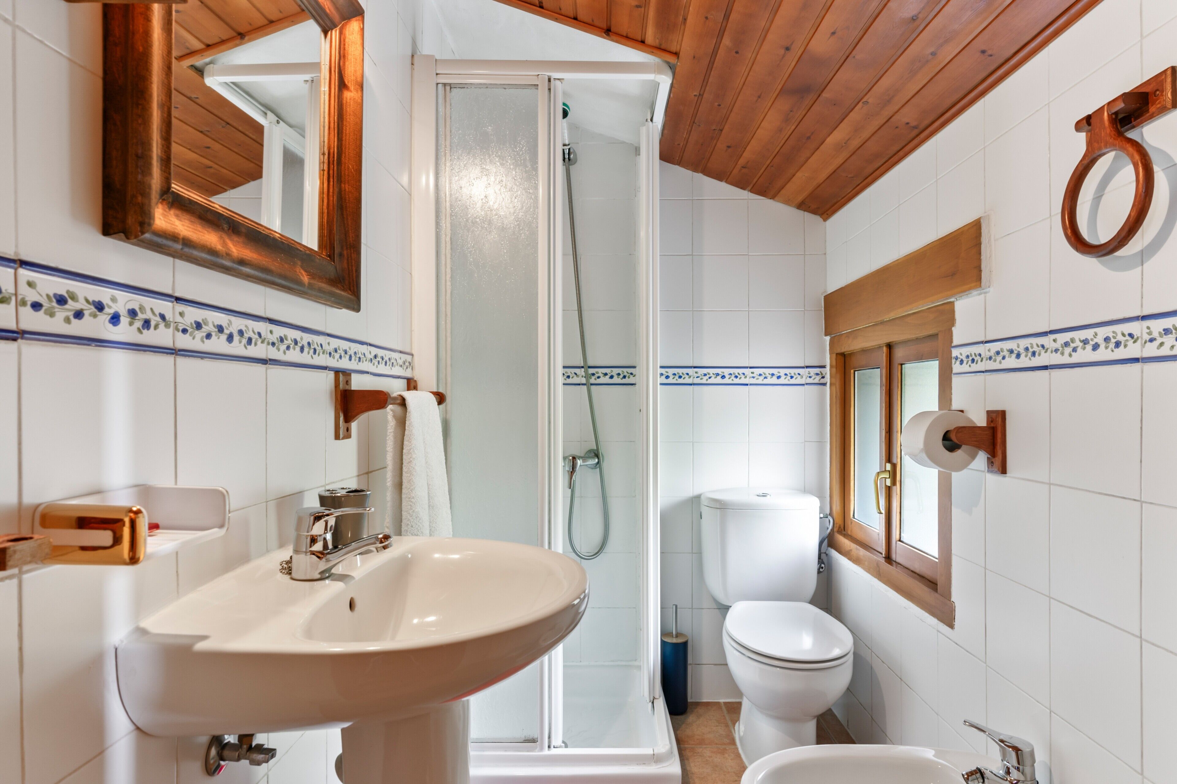 Un baño con lavabo, inodoro, ducha y espejo.