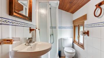 Un baño con lavabo, inodoro, ducha y espejo.