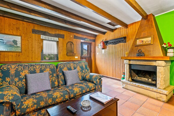 A wooden interior with a sofa, fireplace, and a green wall.