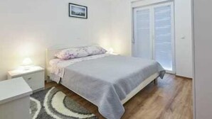 A bedroom with a bed, bedside table, and a window.