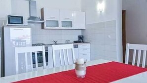 A modern kitchen with white cabinets, a microwave, and a coffee maker.