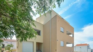 Un bâtiment moderne à deux étages, doté d’un toit plat et d’un garage.