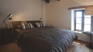A bedroom with a large bed, a nightstand, a desk lamp, and a window with blinds. - Artistic Villa B1 - Adriatic Luxury Villas (Radetići)