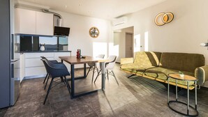 A modern apartment with a kitchen, dining area, and living room.