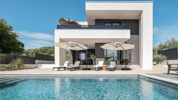 A modern two-story house with a swimming pool, outdoor seating, and a patio area. - Villa Dekorti | Adriatic Luxury Villas (Kožino)