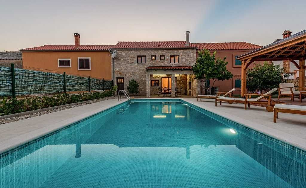 A swimming pool with a stone facade building in the background.