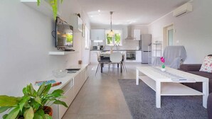 A modern apartment with a kitchen, dining area, and living room. - Villa Meline | Adriatic Luxury Villas (Donja Hlapa)