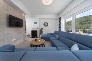 Smart-tv, eldstad och ett bordtennisbord