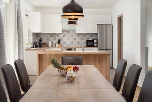 Enjoy meals in the kitchen with a central island, stainless steel appliances, and a dining area with a wooden table and six comfortable chairs.