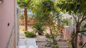 A narrow pathway leading to a balcony overlooking a body of water with trees and shrubs.