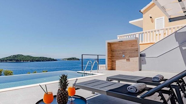A rooftop pool area with lounge chairs, a table with drinks, and a view of the sea. - Villa Evia | Adriatic Luxury Villas (Blato)