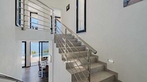 A modern interior with a staircase, a dining area, and a view of the outdoors. - Villa Evia | Adriatic Luxury Villas (Blato)