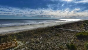 Una playa con una valla de madera y cielo despejado.