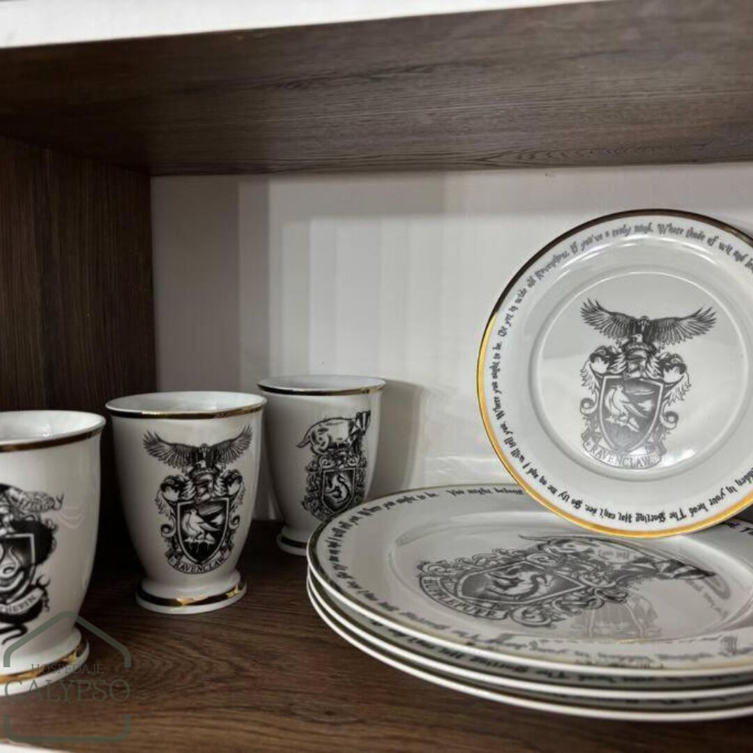 A stack of white plates with gold rims and black embossed designs, including an eagle and shield, on a wooden shelf.